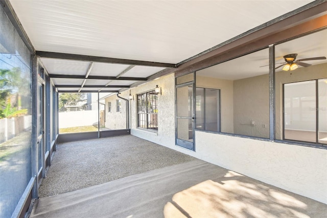 unfurnished sunroom with beamed ceiling and ceiling fan