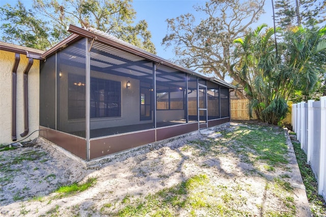 rear view of property featuring glass enclosure