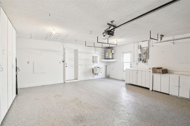 garage featuring sink, a garage door opener, and water heater