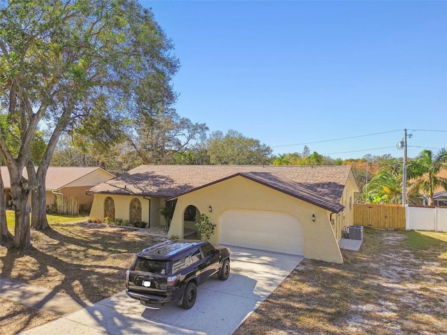 single story home featuring a garage and central AC unit