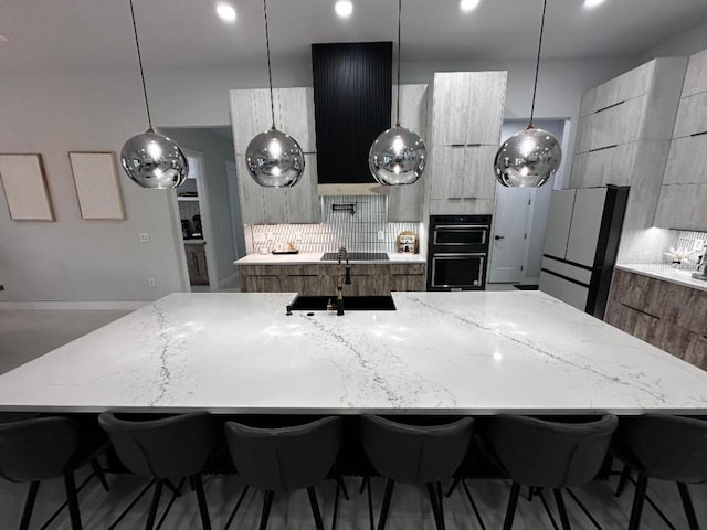 kitchen featuring a kitchen bar, tasteful backsplash, a spacious island, and black appliances