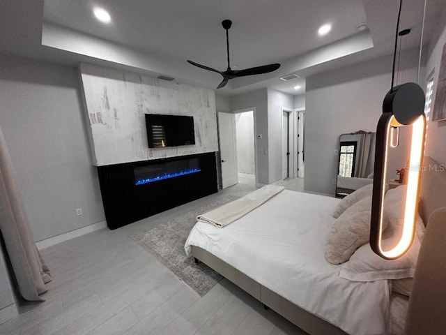 bedroom featuring a raised ceiling and ceiling fan