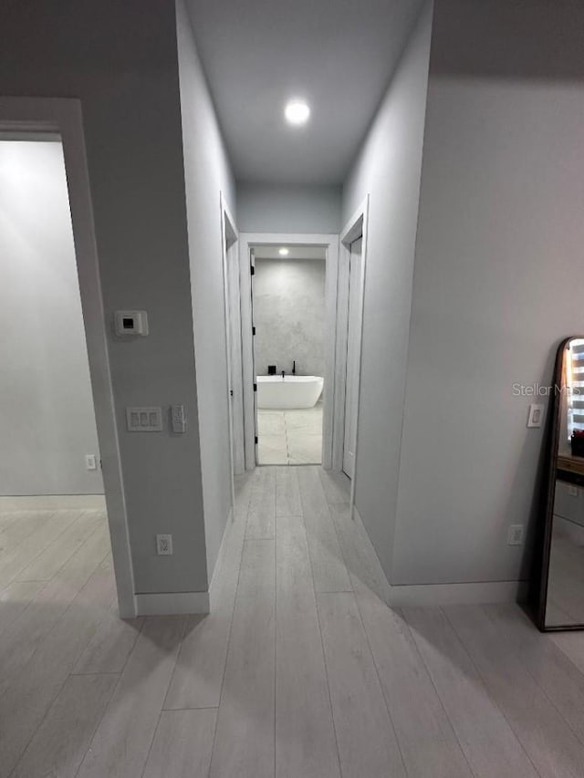 hallway with light hardwood / wood-style floors