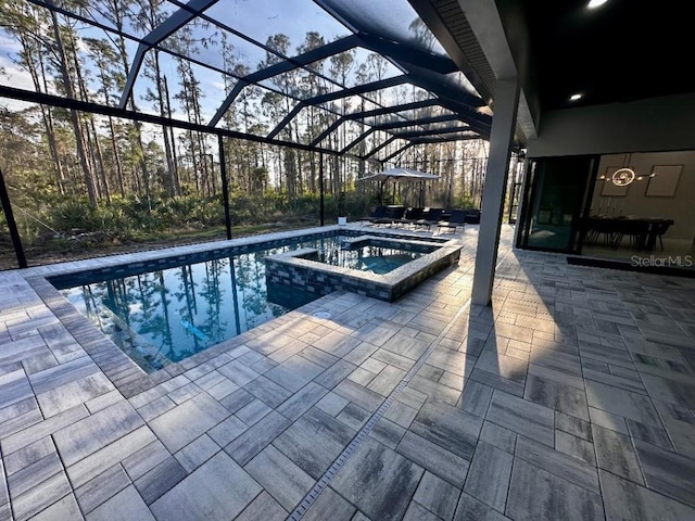 view of swimming pool with a patio area, a lanai, and an in ground hot tub