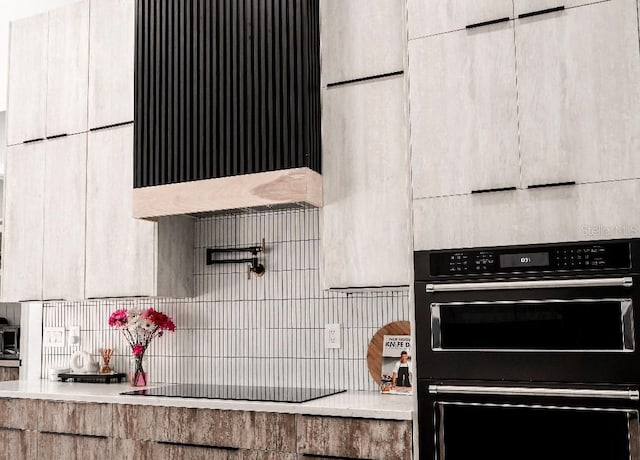 kitchen featuring light countertops, black appliances, and modern cabinets