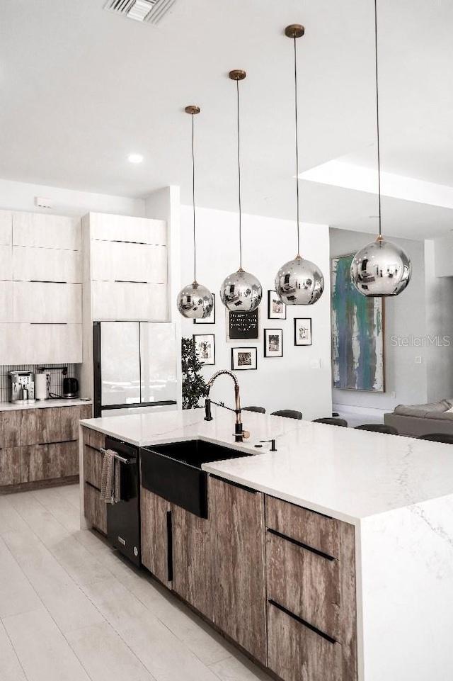 kitchen featuring a sink, black dishwasher, hanging light fixtures, white fridge, and modern cabinets