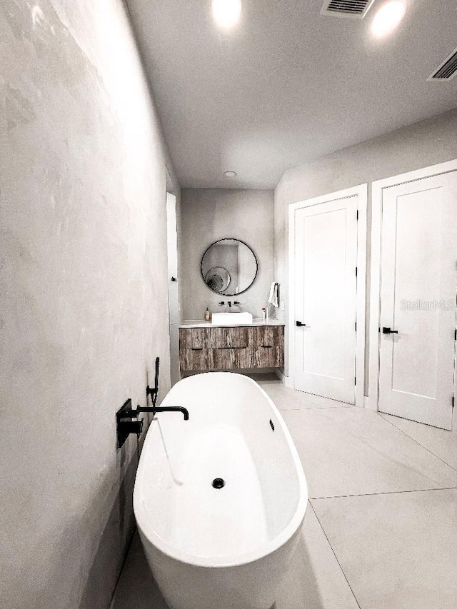 full bath featuring visible vents, a freestanding bath, and vanity