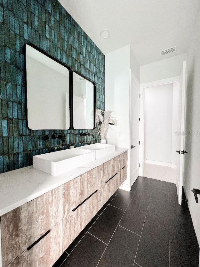 bathroom with baseboards, vanity, visible vents, and tile patterned floors