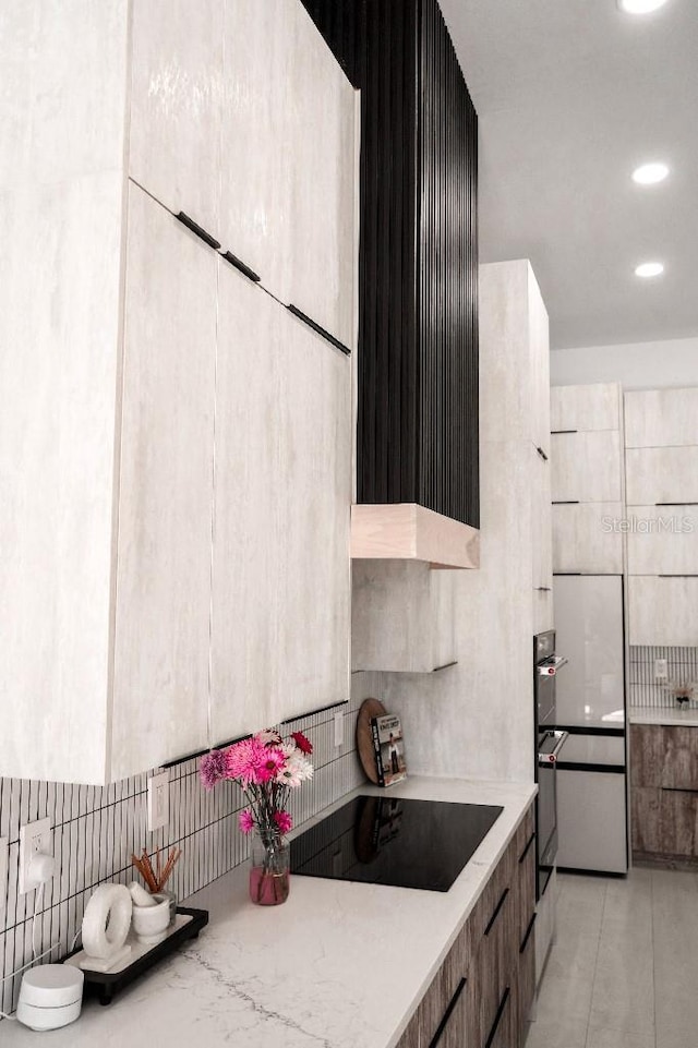 kitchen with light tile patterned floors, black electric cooktop, modern cabinets, and light countertops