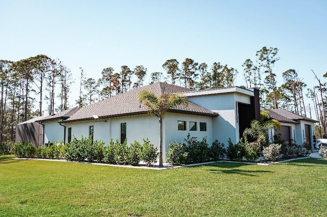 view of property exterior with a garage, stucco siding, and a yard