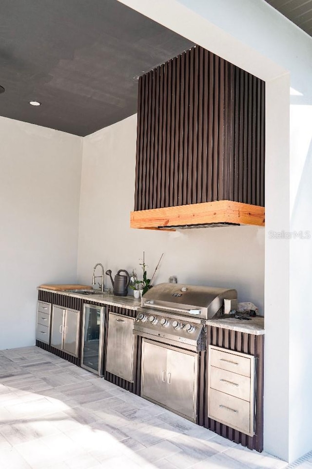 view of patio / terrace featuring beverage cooler, grilling area, an outdoor kitchen, and a sink