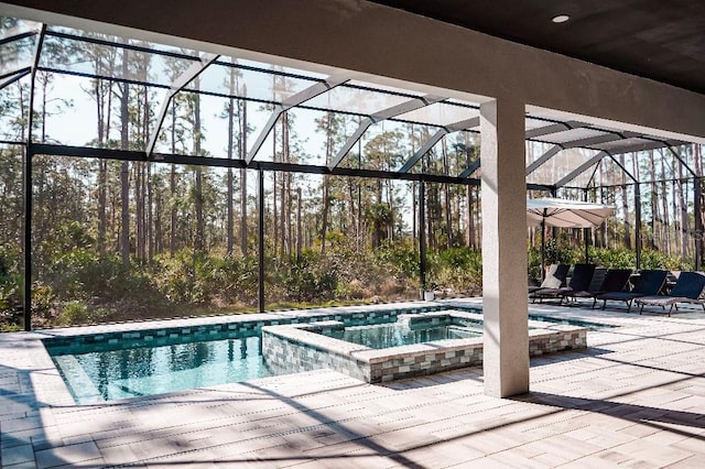 view of pool featuring a lanai, a patio area, and a pool with connected hot tub