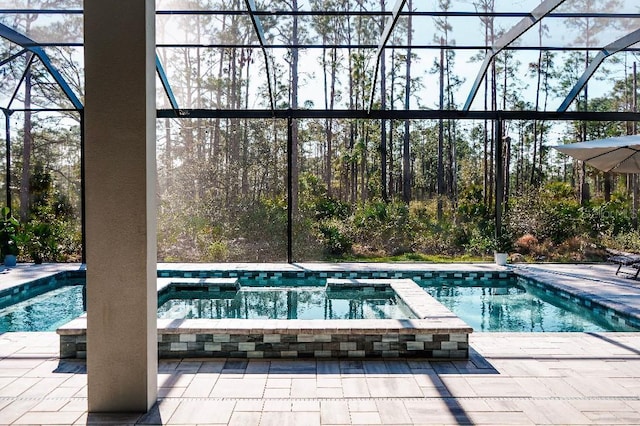 view of swimming pool featuring a lanai, a patio area, and a pool with connected hot tub