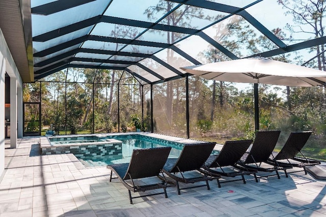 view of pool featuring a pool with connected hot tub, a lanai, and a patio