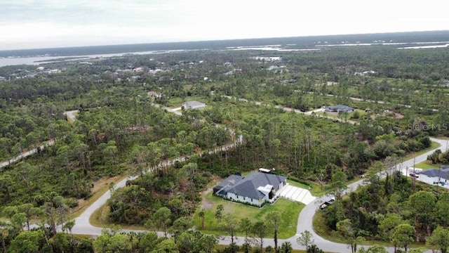 aerial view with a water view and a wooded view