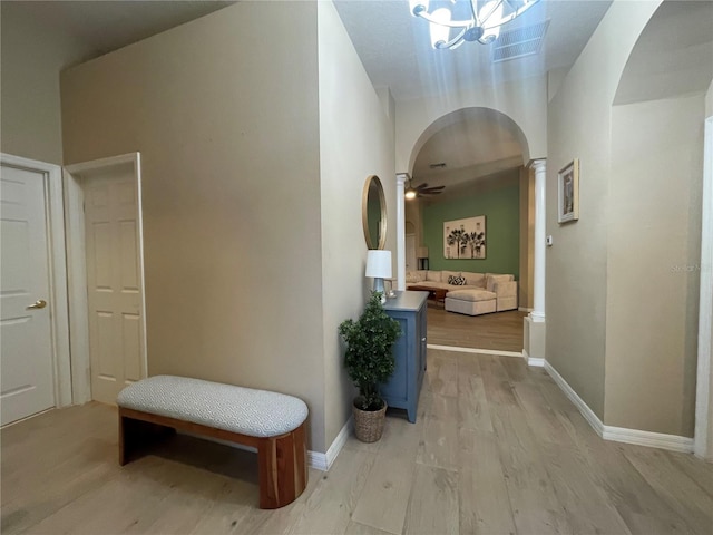 hallway with light hardwood / wood-style floors and a chandelier