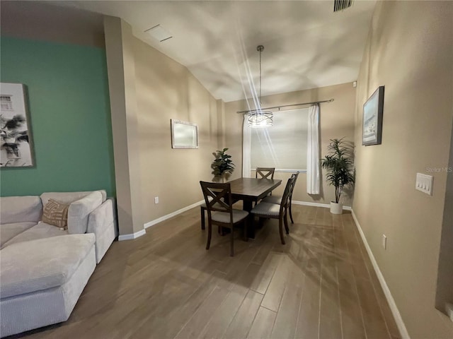 dining space with hardwood / wood-style floors and lofted ceiling