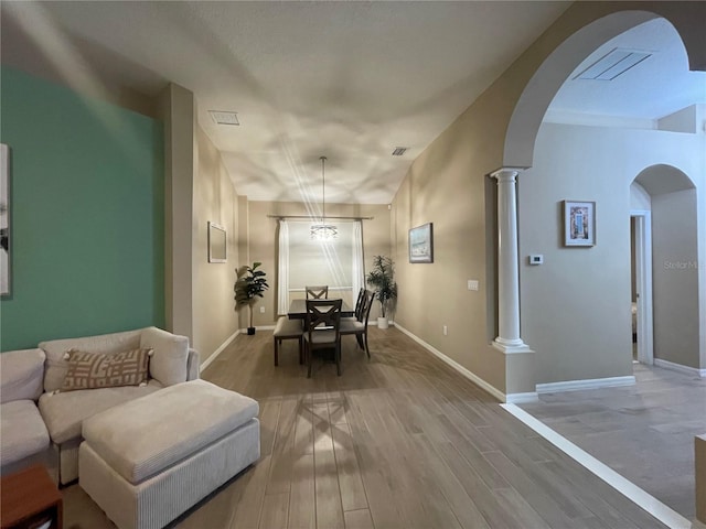 dining area featuring decorative columns and light hardwood / wood-style flooring