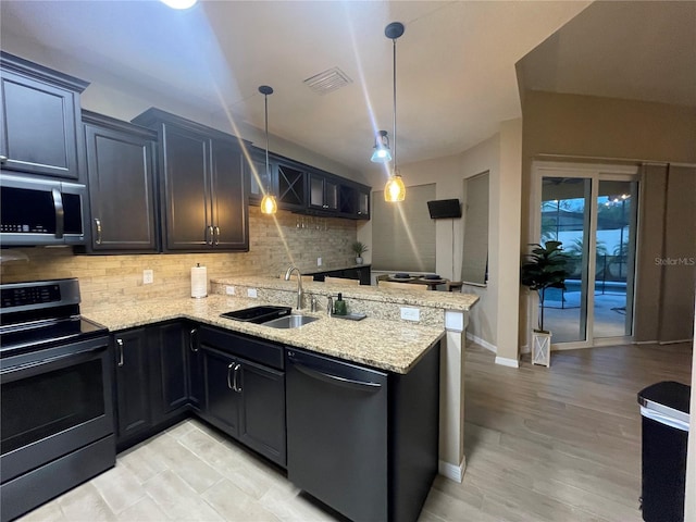 kitchen with sink, light stone counters, decorative light fixtures, decorative backsplash, and appliances with stainless steel finishes