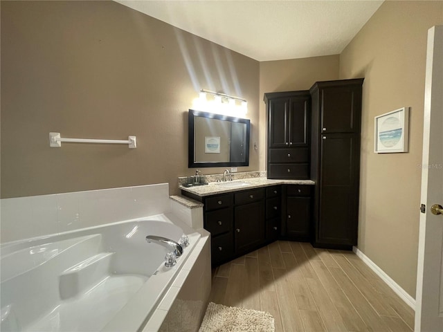 bathroom featuring vanity, a relaxing tiled tub, and hardwood / wood-style flooring