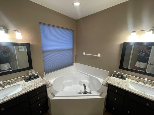 bathroom with vanity and tiled bath