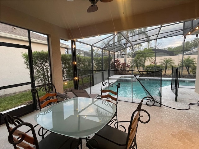 view of pool featuring an in ground hot tub, glass enclosure, and a patio area