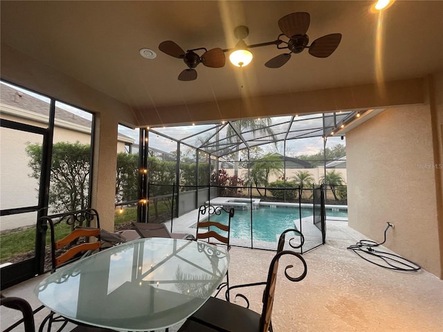 view of swimming pool with a patio area, ceiling fan, and glass enclosure