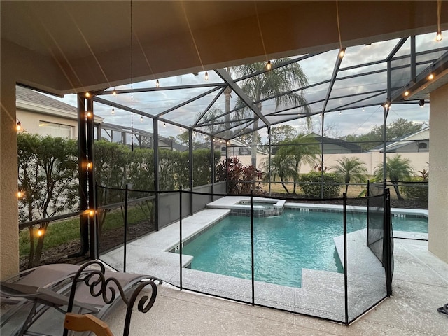 pool at dusk with glass enclosure, an in ground hot tub, and a patio