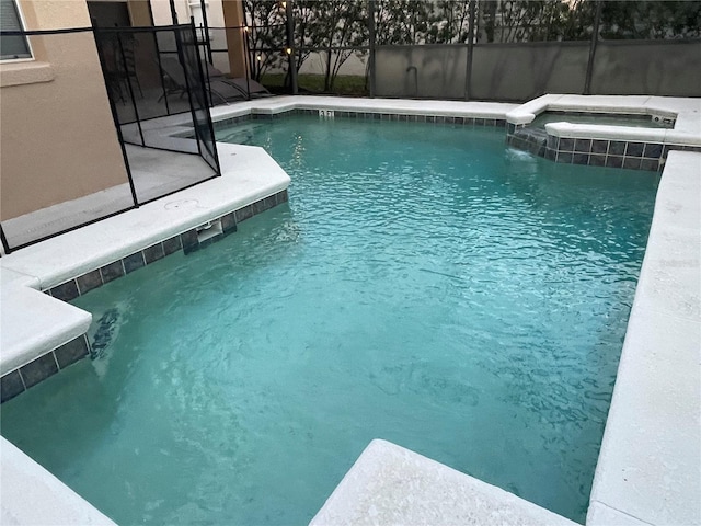 view of swimming pool featuring a lanai