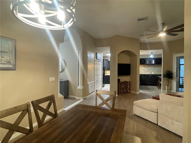 living room with hardwood / wood-style floors and ceiling fan with notable chandelier