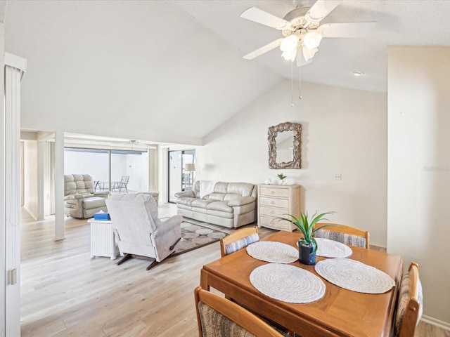 dining space featuring ceiling fan, light wood-type flooring, and lofted ceiling