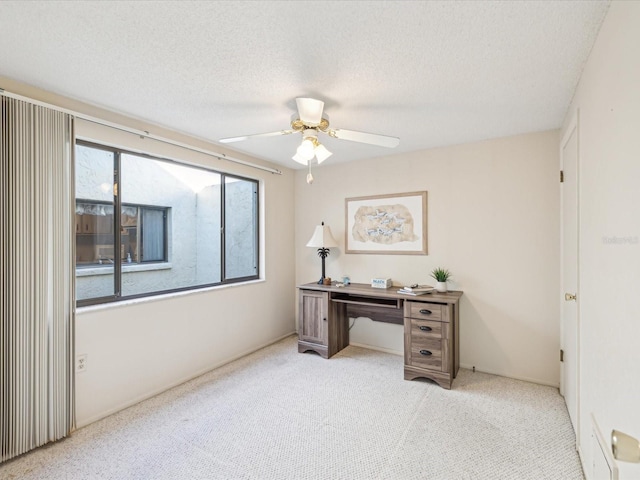 office with a textured ceiling, light colored carpet, and ceiling fan