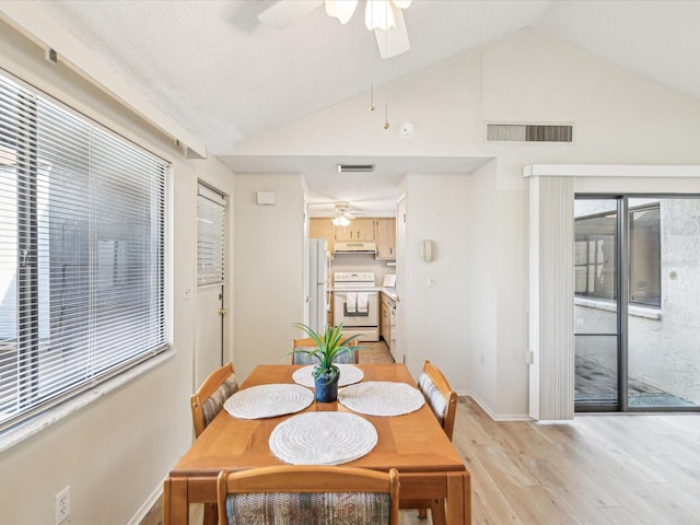 dining room with ceiling fan, light wood-type flooring, and lofted ceiling