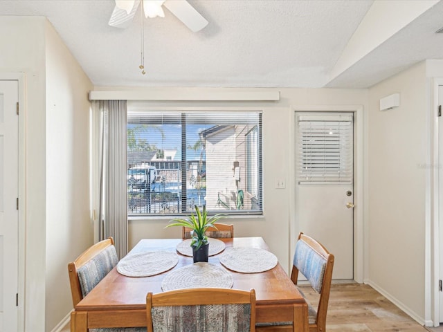 dining space featuring ceiling fan, light hardwood / wood-style floors, and lofted ceiling