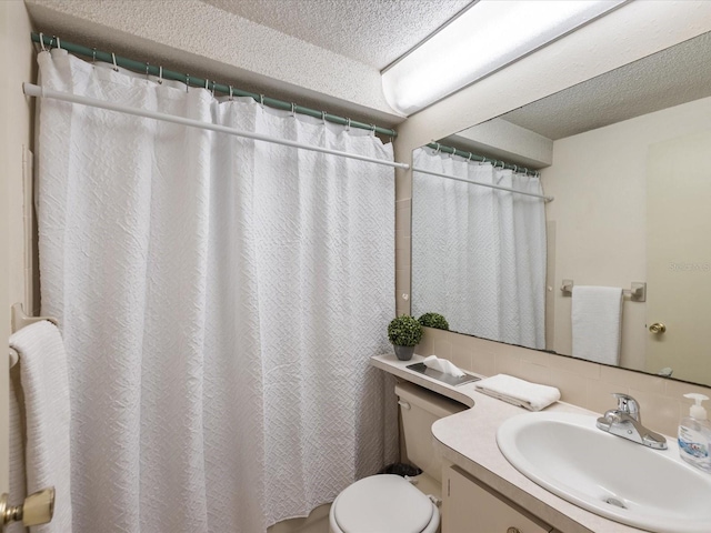 bathroom with vanity, a textured ceiling, and toilet