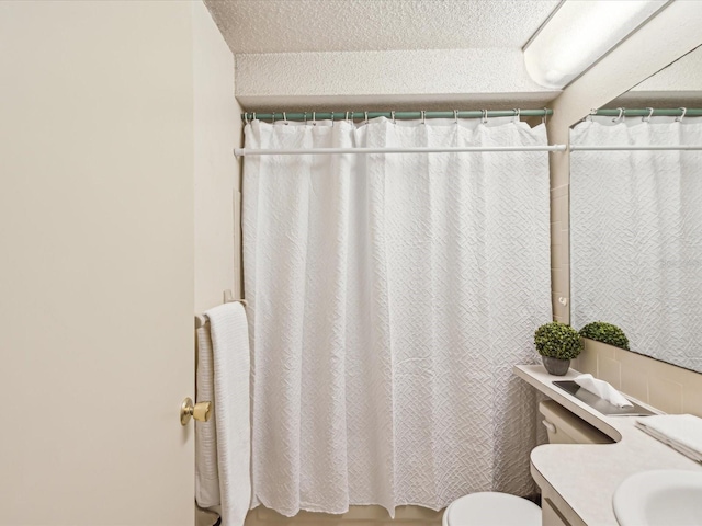 bathroom with vanity, curtained shower, and toilet