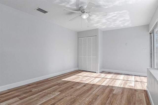 unfurnished bedroom featuring ceiling fan, a closet, and light wood-type flooring