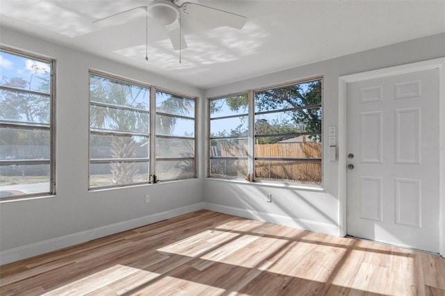 unfurnished sunroom featuring plenty of natural light and ceiling fan