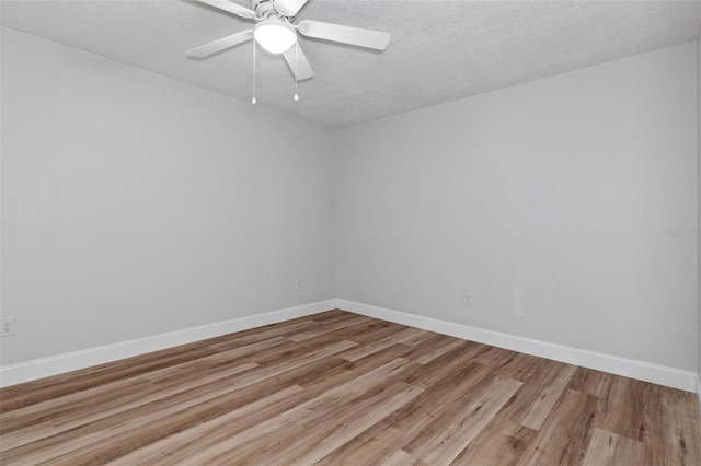 empty room with ceiling fan, light hardwood / wood-style floors, and a textured ceiling