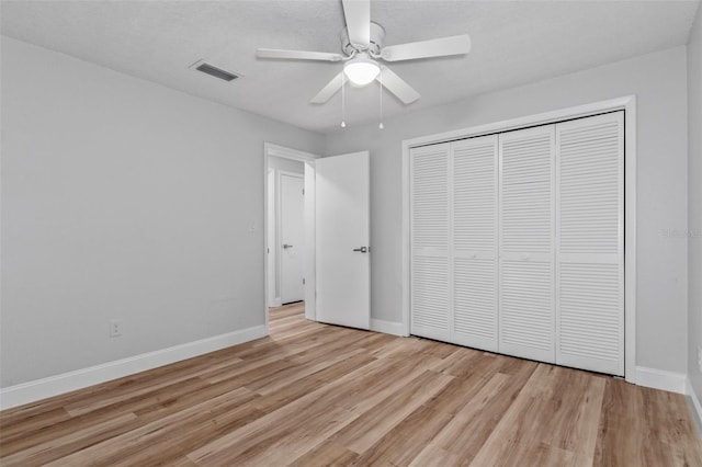 unfurnished bedroom featuring a closet, light hardwood / wood-style flooring, and ceiling fan