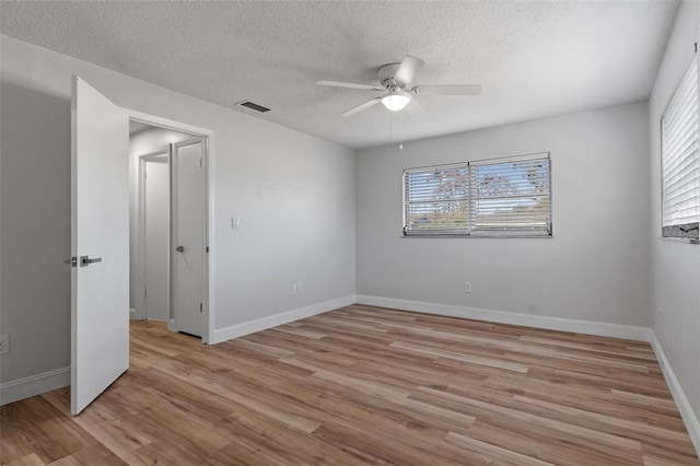 spare room with ceiling fan, a textured ceiling, and light hardwood / wood-style flooring