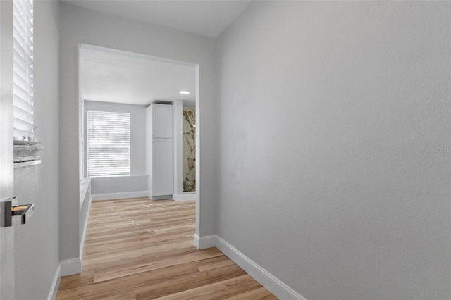 hallway with light hardwood / wood-style floors