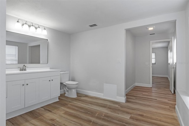 bathroom featuring vanity, hardwood / wood-style flooring, and toilet