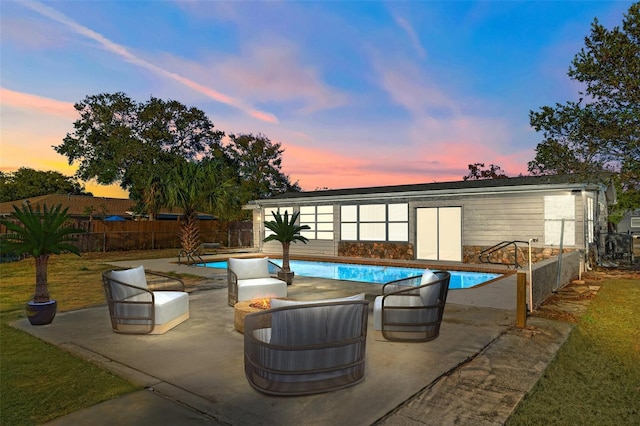 patio terrace at dusk with a fenced in pool