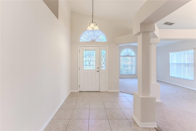 foyer entrance featuring a chandelier, light tile patterned floors, and lofted ceiling