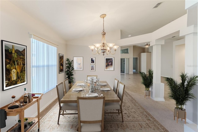 dining room featuring ceiling fan with notable chandelier, light tile patterned floors, and vaulted ceiling