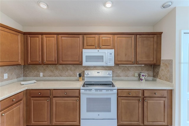 kitchen with decorative backsplash and white appliances