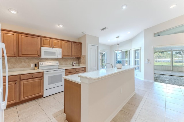 kitchen with decorative backsplash, lofted ceiling, decorative light fixtures, white appliances, and a kitchen island with sink