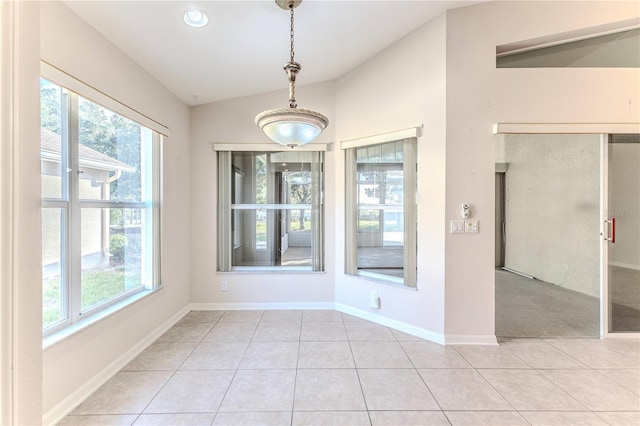 unfurnished dining area with light tile patterned floors and lofted ceiling