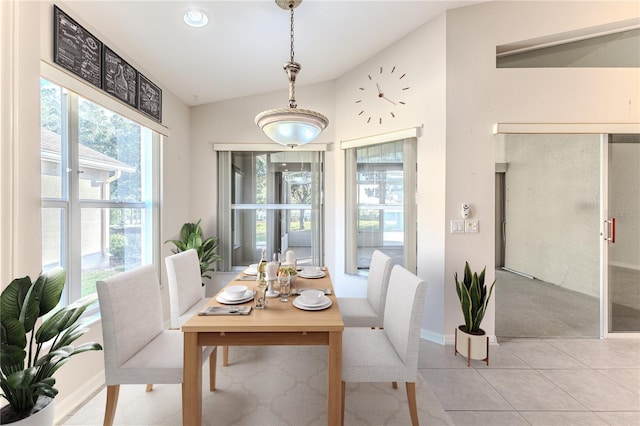 tiled dining room featuring vaulted ceiling